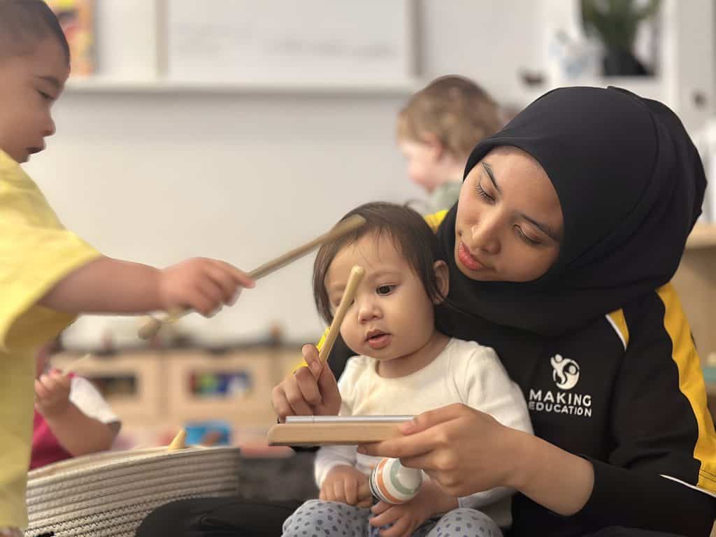 Educator and child with a musical instrument