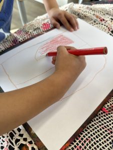 Child drawing with red.